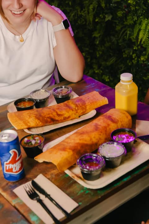 A golden dosa lifted and folded with a spatula