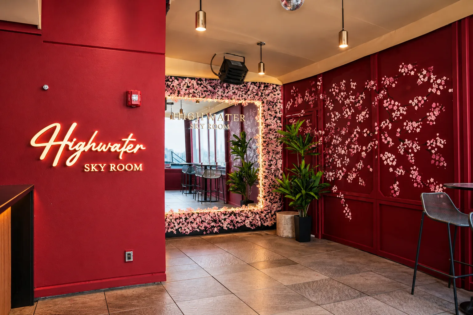 Sky Room with red walls, a floral mirror, and illuminated Highwater signage