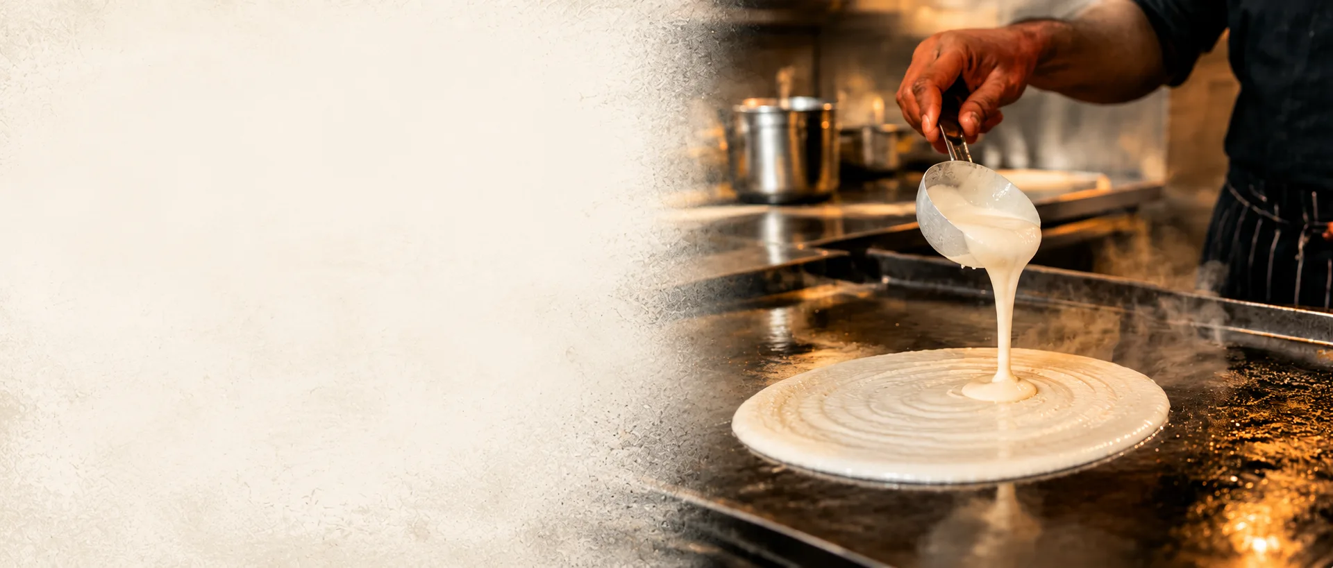 A Madras Dosa Co cook ladling dosa batter onto a hot griddle in a spiral