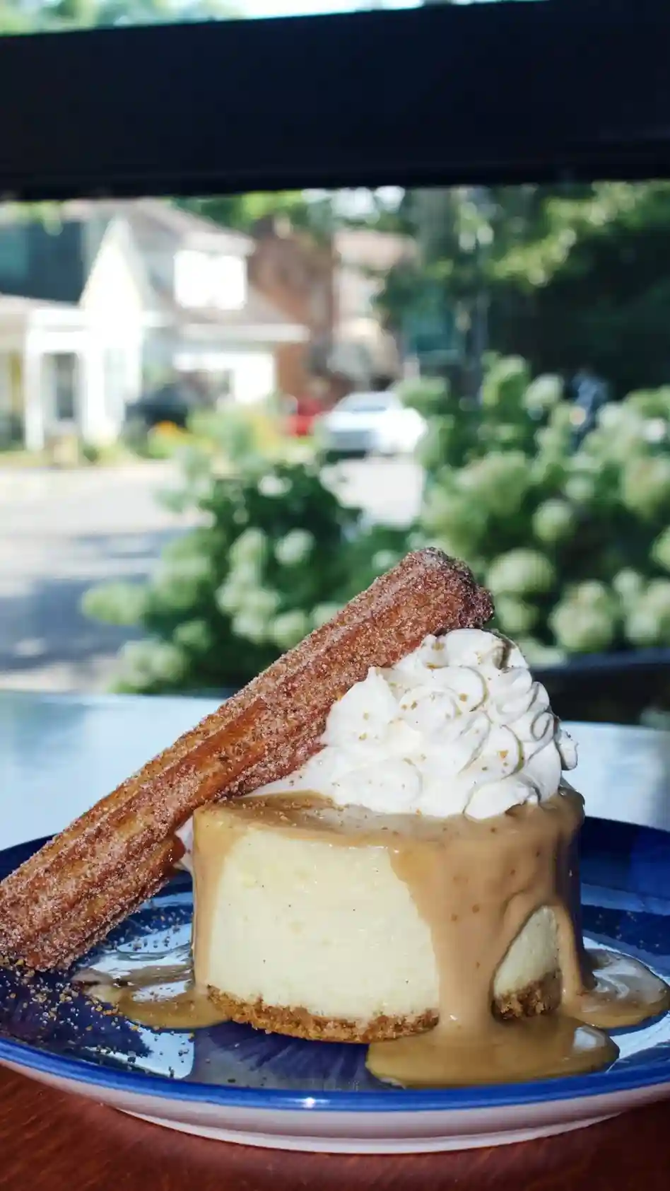 Cheesecake with caramel sauce, whipped cream and a churro