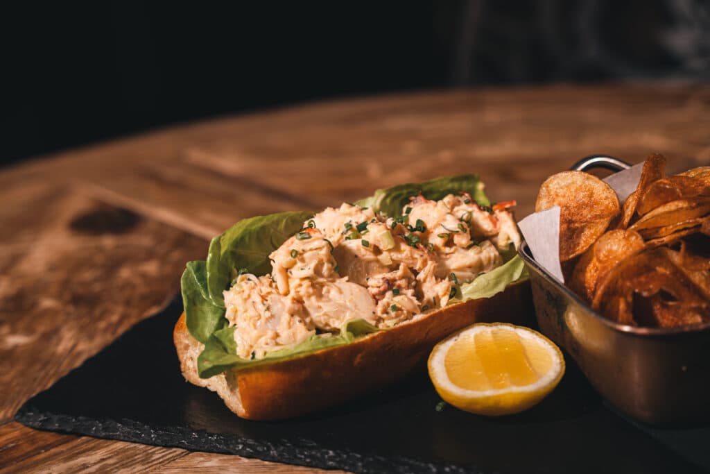 Maine lobster roll with house chips at The Addison restaurant in Midtown Manhattan