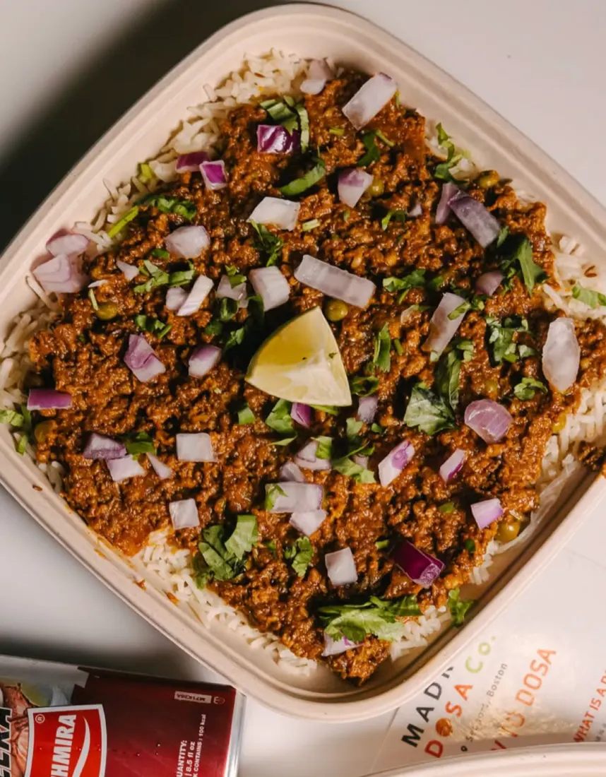 Pulao topped with onions, cilantro and lime
