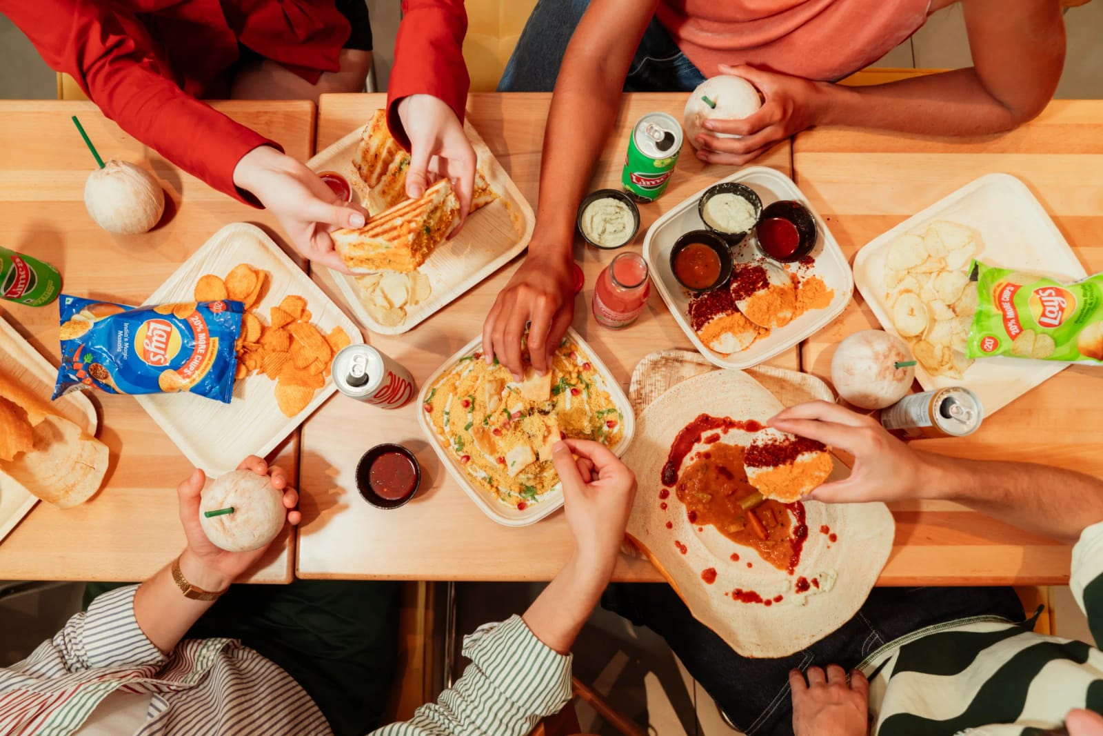 A table of dosas, chaats and sides shared by a group