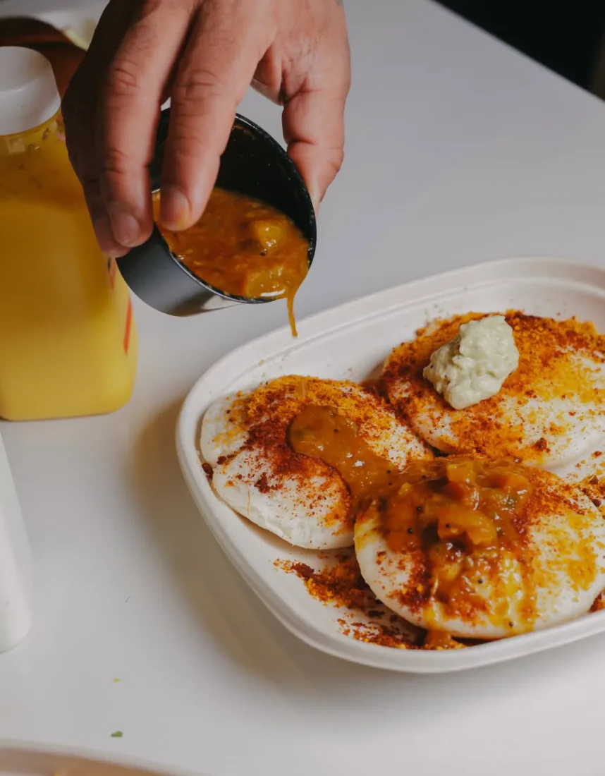 Sambar being poured over idly
